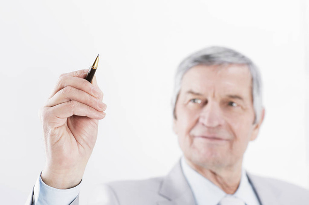 Mature businessman showing a pencil on the copy space. - Фото, зображення