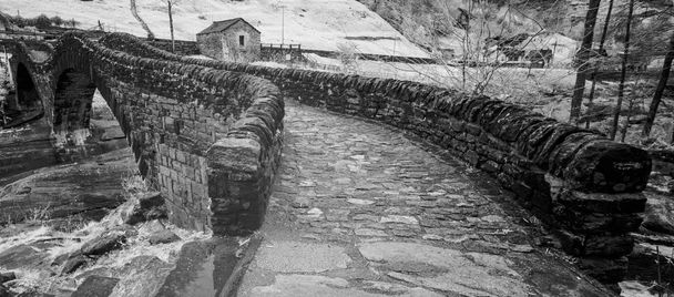 Schwarz-weiß Nahaufnahme einer historischen Steinbrücke aus der Römerzeit in einem abgelegenen Bergtal - Foto, Bild