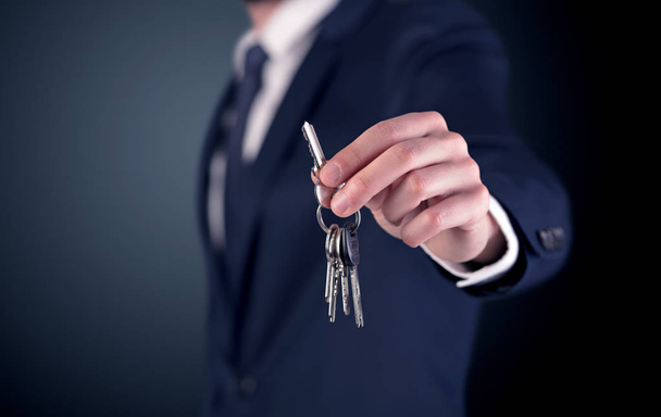 Young man hand over keys  - Фото, изображение