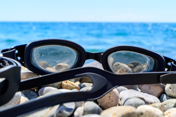 ξαπλωμένη πάνω στα βότσαλα από τη θάλασσα, τη Μαύρη Θάλασσα καλοκαίρι γυαλιά - Φωτογραφία, εικόνα