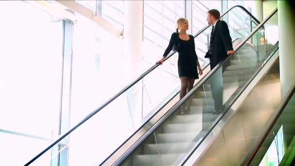 Reunión de pareja de negocios sobre escaleras mecánicas en movimiento
 - Imágenes, Vídeo