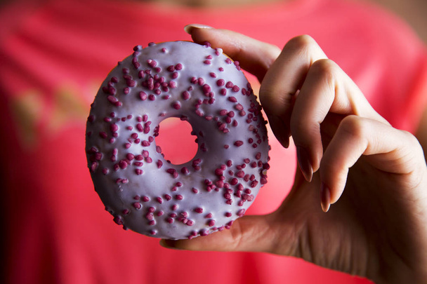 Woman holding delicious donut.  - Foto, afbeelding