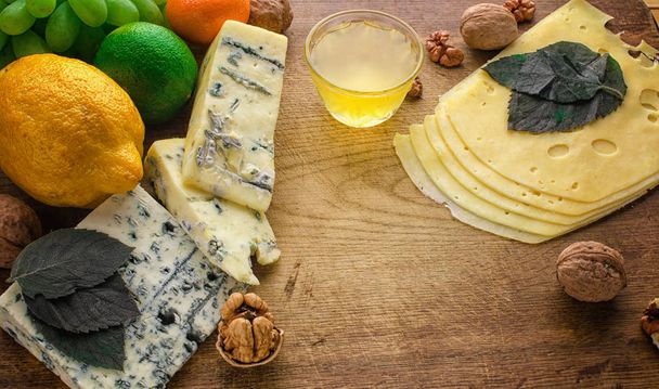 Peynir tabağı ile farklı peynirler, üzüm, fındık, tatlım ve tarihleri rustik ahşap zemin üzerinde. Retro peynir çeşitli seçim ahşap tahta üzerinde tarz. - Fotoğraf, Görsel