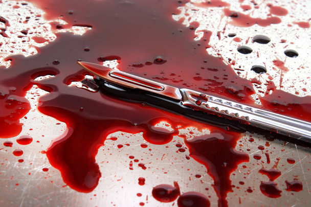 Coltello da chirurgo sul tavolo autoptico in acciaio inossidabile con molto sangue
 - Foto, immagini
