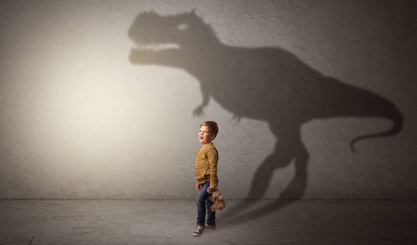 Dinosaurus σκιά πίσω από το χαριτωμένο αγόρι - Φωτογραφία, εικόνα