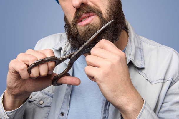 Man cut his beard with big scissors close up - Foto, afbeelding