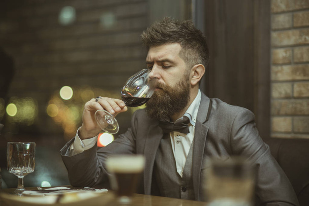 Red wine, man evaluates the color of wine in a glass. Sommelier tasting red wine - Φωτογραφία, εικόνα