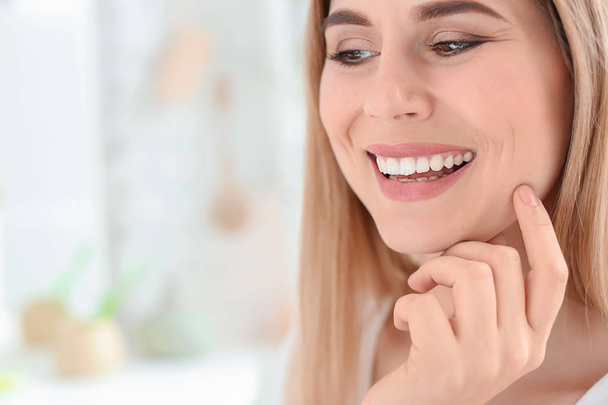 Young woman with beautiful smile indoors. Teeth whitening - Foto, Bild
