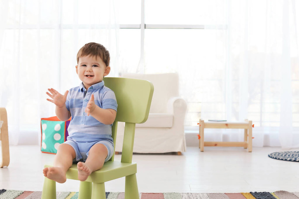 Cute baby sitting on chair at home - Foto, imagen
