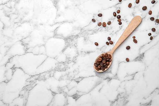 Spoon with coffee beans on marble background, top view - Φωτογραφία, εικόνα