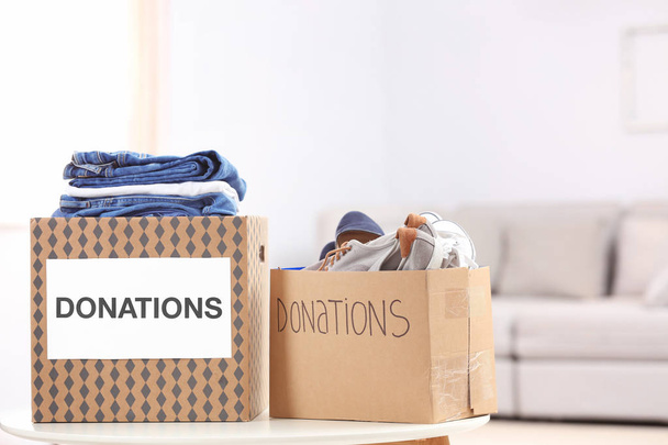 Donation boxes with clothes and shoes on table indoors - Photo, Image