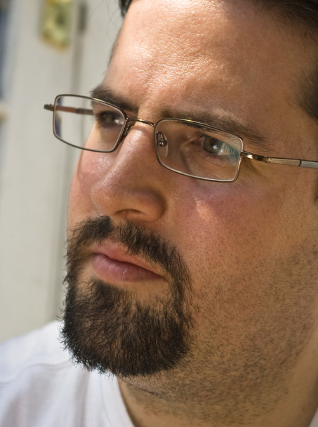 Man with beard and glasses looks left intently - Photo, Image