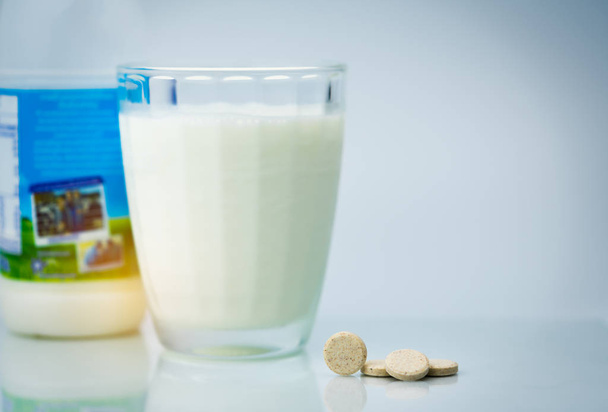 風味を付けられたミルク錠とグラス一杯の牛乳や牛乳瓶白い背景の上に甘くなります。健康な骨のための牛乳からカルシウム食品. - 写真・画像