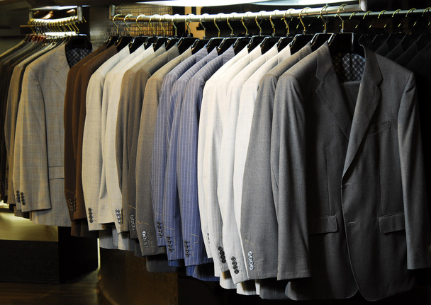 Surowe w różnych kolorach męskie kurtki wiszące na odzieży. - Zdjęcie, obraz