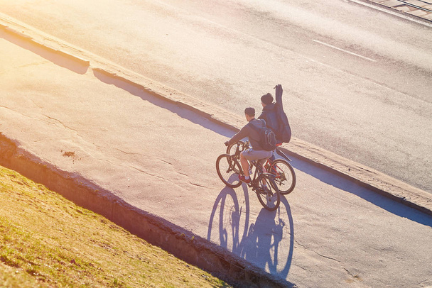 Παιδιά με καλάμια στα ποδήλατα στον ήλιο - Φωτογραφία, εικόνα