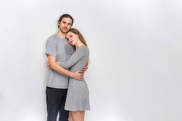 young and beautiful man and woman are standing on white background in different poses - Foto, Bild