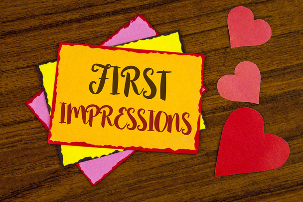 Text sign showing First Impressions. Conceptual photo Encounter presentation performance job interview courtship written on Sticky note paper on wooden background Hearts next to it. - Photo, Image