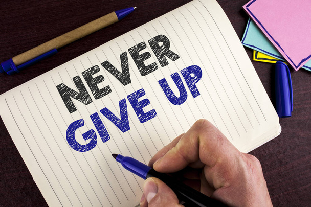 Conceptual hand writing showing Never Give Up. Business photo showcasing Be persistent motivate yourself succeed never look back written by Man on Notebook Book on wooden background Pen. - Foto, Imagen
