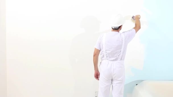 schilder man aan het werk met borstel, muurschildering concept, wit copy ruimte achtergrond - Video