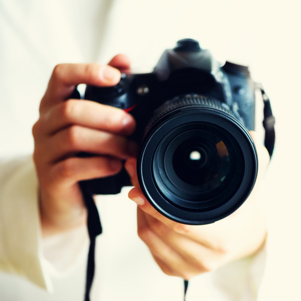 Mãos de menina segurando câmera de foto, fundo branco, espaço de cópia. Viajar e atirar conceito. Culturas quadradas
 - Foto, Imagem