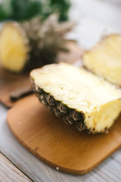 Sliced fresh pineapple on a wooden background in sunlight - Foto, imagen