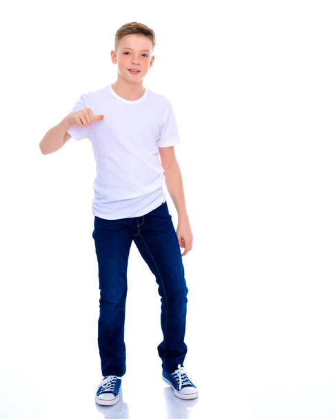 Un ragazzo della scuola indica la sua maglietta bianca
. - Foto, immagini