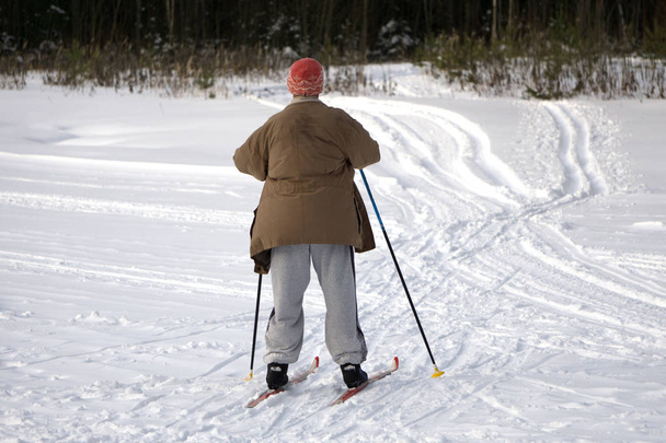 Active happy healthy grandpa , skiing in the snowy forest on a Sunny winter day - Foto, imagen