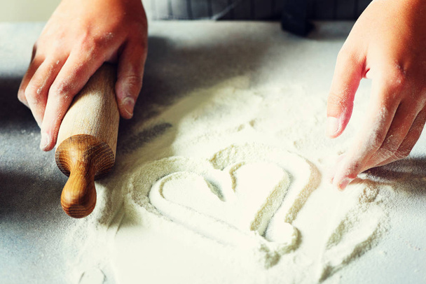 Heart of flour. Baking background with rolling pin, eggs, milk, butter on white kitchen table. Valentines day cooking, love concept. - Photo, Image