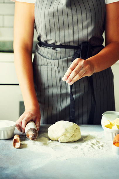 Female hands kneading dough, baking background. Cooking ingredients - eggs, flour, sugar, butter, milk, rolling pin on white style kitchen. Copy space - Foto, Imagem