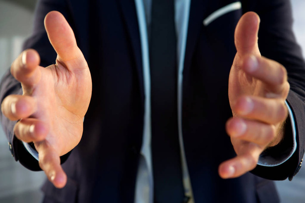 Businessman holding empty hands at office - Foto, imagen
