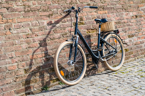 Bicicleta vintage retro negra con pared de ladrillo viejo
. - Foto, imagen