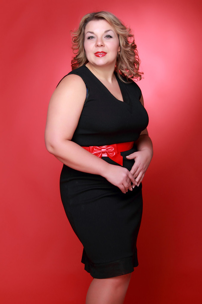 Portrait of a beautiful woman on a red background - Zdjęcie, obraz