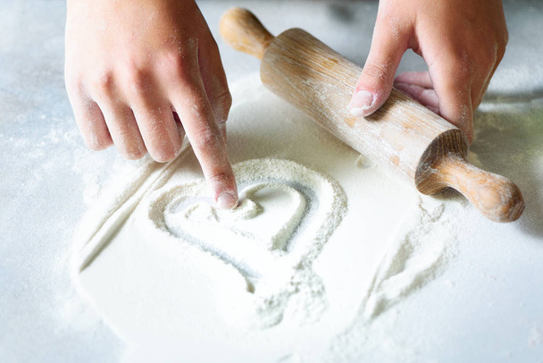 Heart of flour. Baking background with rolling pin, eggs, milk, butter on white kitchen table. Valentines day cooking, love concept. - Fotoğraf, Görsel