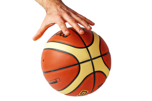 Χέρι που φθάνει για μια μπάλα του μπάσκετ σε λευκό φόντο - Φωτογραφία, εικόνα