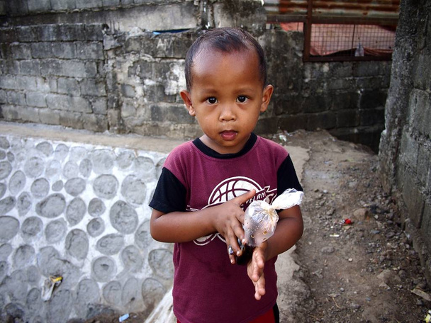 Young Filipino boy stops playing to pose for the camera. - Photo, Image