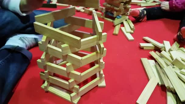 niños juegan con bloques de madera construyendo una torre
 - Metraje, vídeo