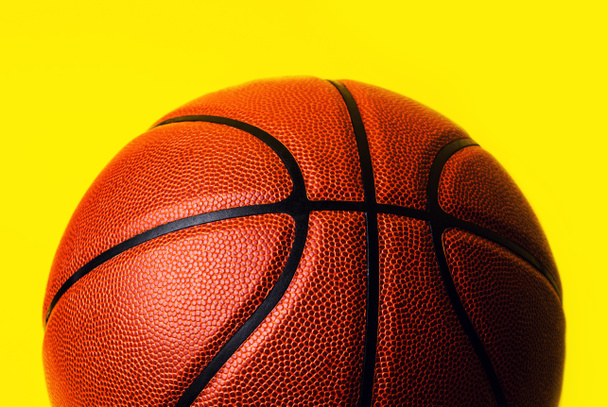 basketbol topu sarı zemin üzerine. - Fotoğraf, Görsel