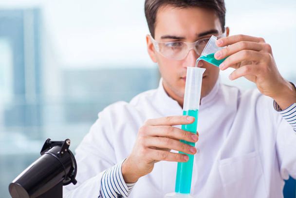 Молодой химик, работающий в лаборатории по химии - Фото, изображение