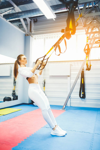 Beautiful woman doing exercise with trx system. - Foto, immagini
