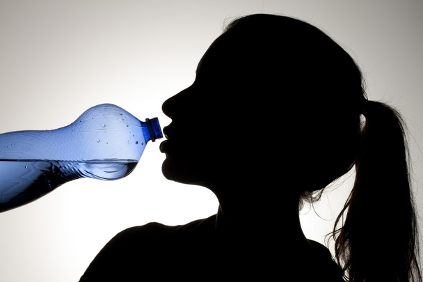青色の瓶から水を飲む女の子 - 写真・画像