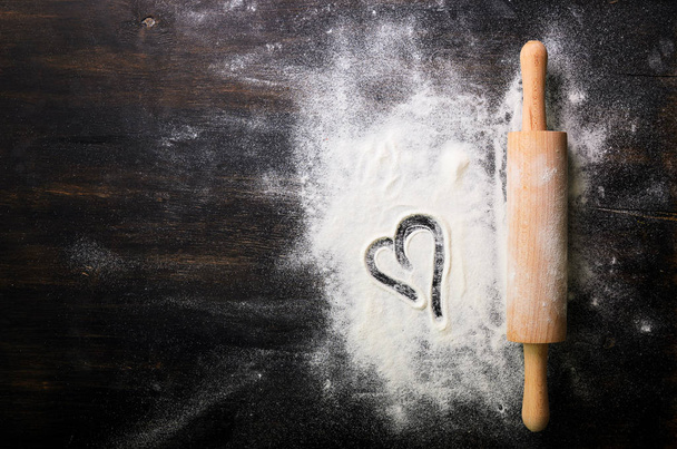 Baking background. Heart of flour and rolling pin on dark table with copy space, top view. Valentines Day - Valokuva, kuva