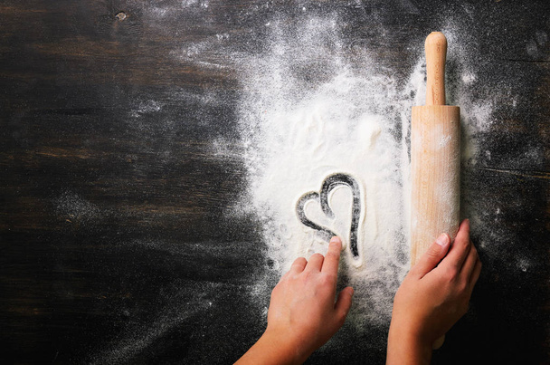 Baking background. Heart of flour and rolling pin on dark table with copy space, top view. Valentines Day - Fotografie, Obrázek