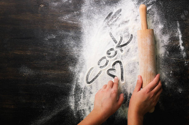 Baking background. Heart of flour, text Cook and rolling pin on dark table with copy space, top view - Фото, зображення