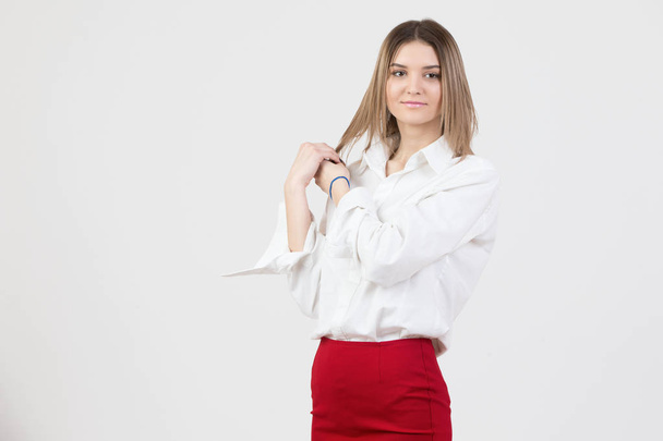 Beautiful young woman in a white shirt and a red skirt on a white background - Foto, Bild