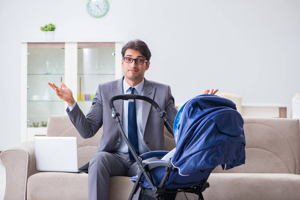 Бизнесмен, ухаживающий за новорожденным ребенком дома и на работе - Фото, изображение