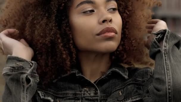 Smíšené rasy černý žena s velkým afro kudrnaté vlasy v přírodě city - Záběry, video