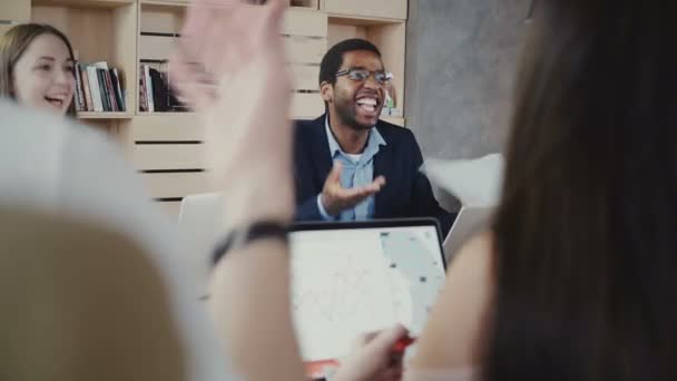 Boss szczęśliwy firmy African American śmieje się spotkanie wieloetnicznym pakietu office, a następnie przechodzi poważne ponownie w modny coworkingowa 4k - Materiał filmowy, wideo