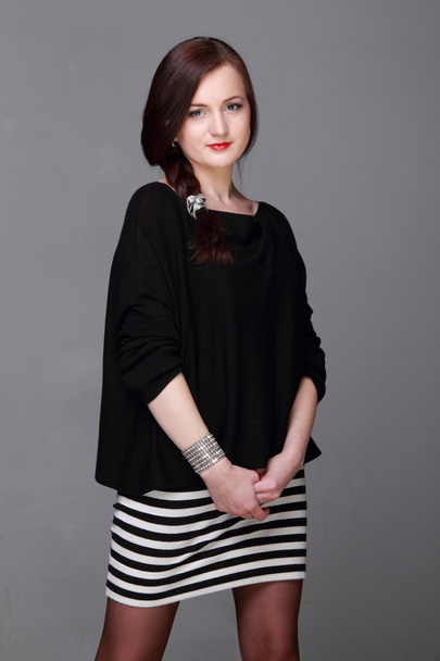 Portrait of a beautiful girl in a striped skirt - Fotó, kép