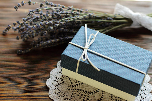 scatola regalo blu per uomo con fiore di lavanda su tavolo di legno, v
 - Foto, immagini