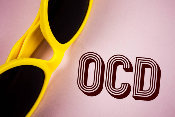 Text sign showing Ocd. Conceptual photo Obsessive Compulsive Disorder Psychological Illness Medical Condition written on Plain Pink background Sunglasses next to it. - Photo, Image